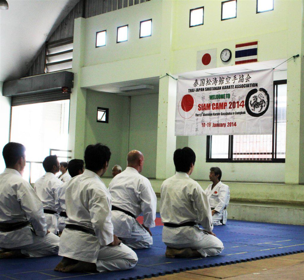 students kneeling in front of sensei and siam camp sign