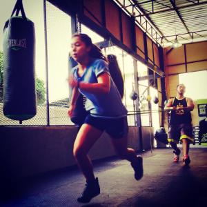girl running pulling the rope at lion's head boxing gym