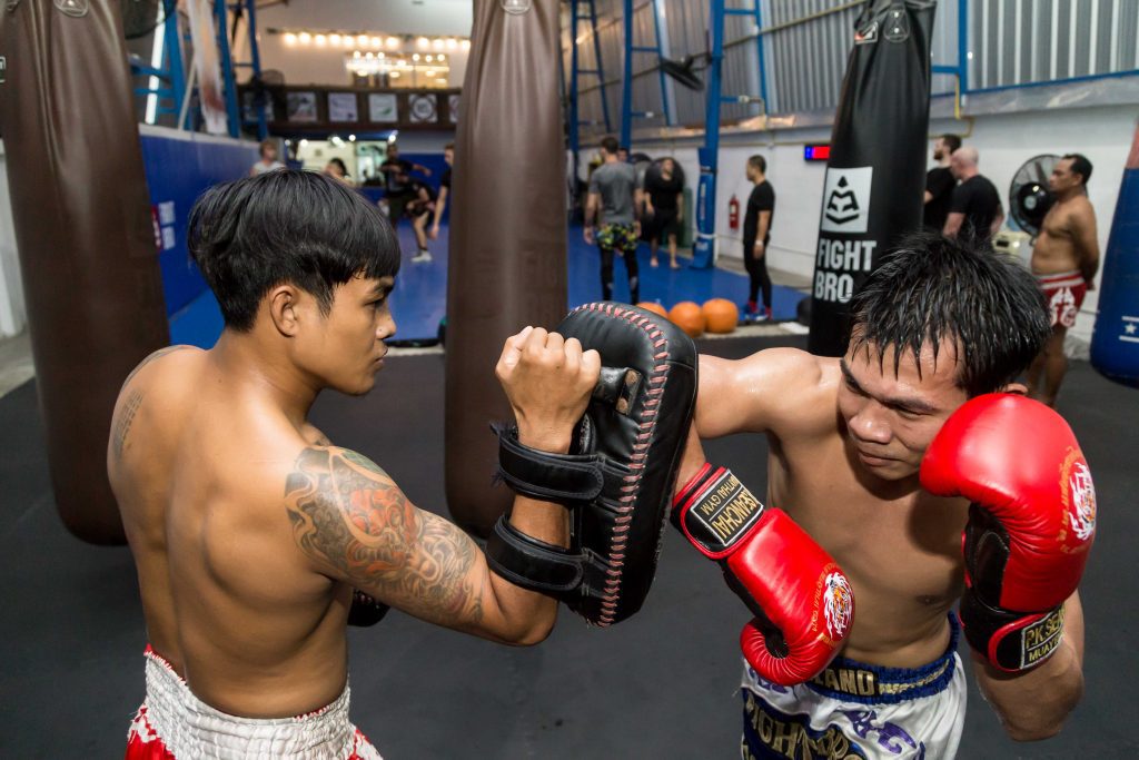 student training elbow strike with pads at bangkok fight lab