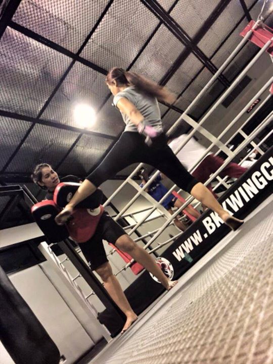girl kicking pad in front of ring at Bangkok wing chun