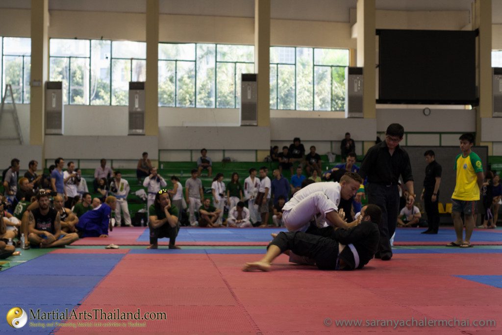 wide view of a bjj match with audience in background