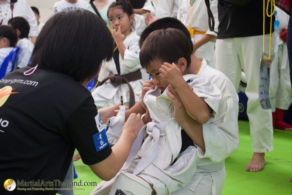 adult helping kid wearing protection gear