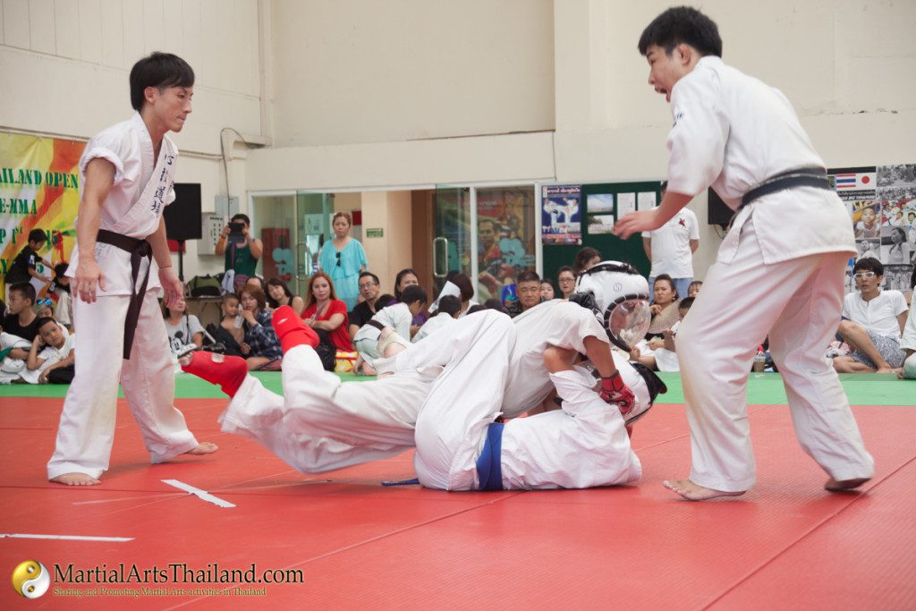 ground fighting action with referees watching