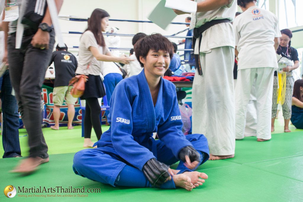 female karate girl smile while stretching wearing blue uniform