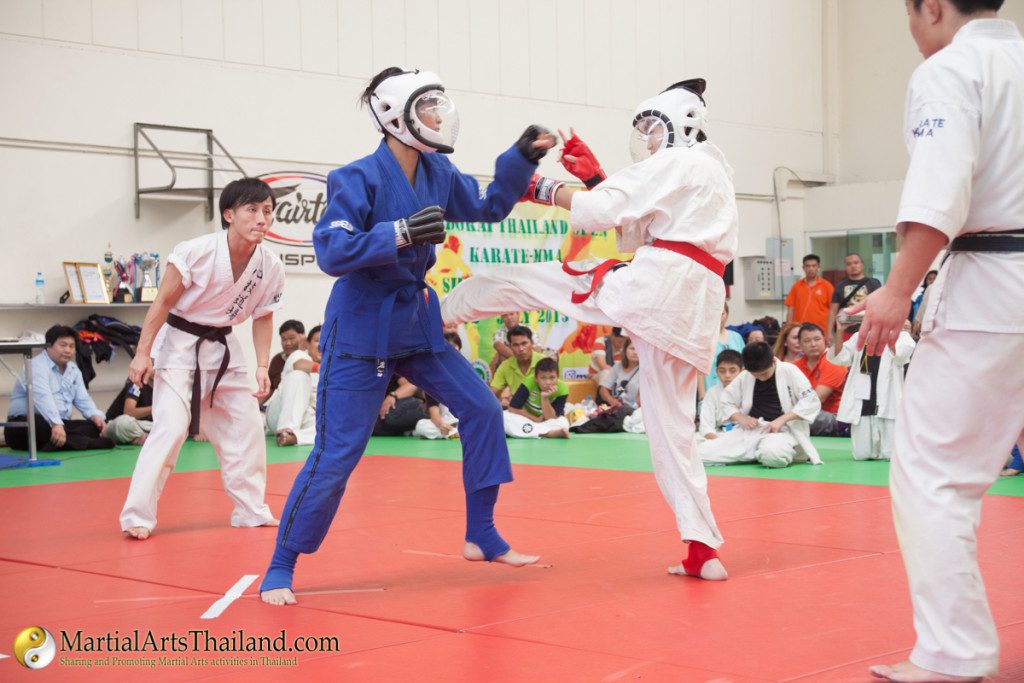 karateka gives middle kick to opponent