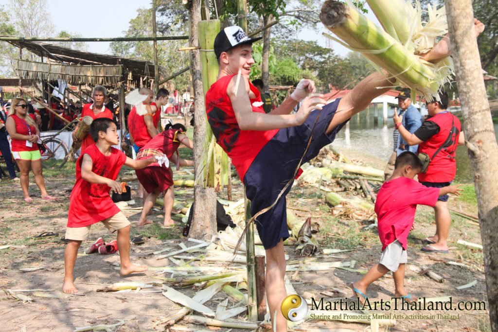 people practicing kicking banana trees at the 12th Wai Kru Muay Thai Ceremony 2016 