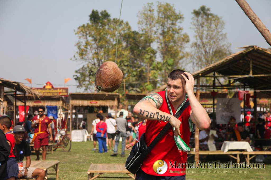 student trying to elbow a swinging coconut tree at the 12th Wai Kru Muay Thai Ceremony 2016 