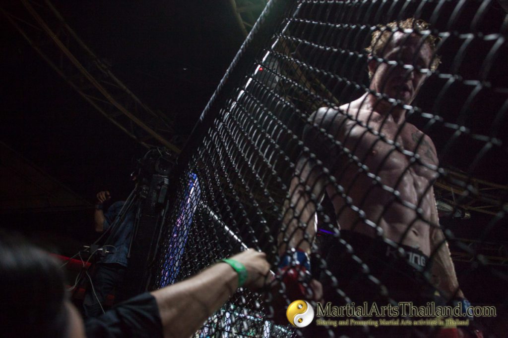 fist bump with fighter thru the cage net at Full Metal Dojo 13 Concrete Jungle