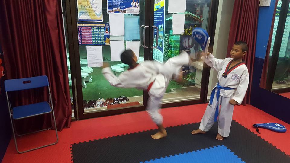 kid student training high kiks with pads at Central Taekwondo Thailand - Hua Hin