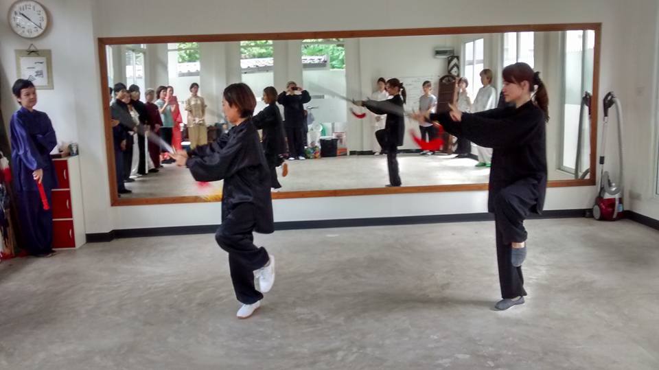 Taiji Chen Bangkok class practising in black uniforms and weapons