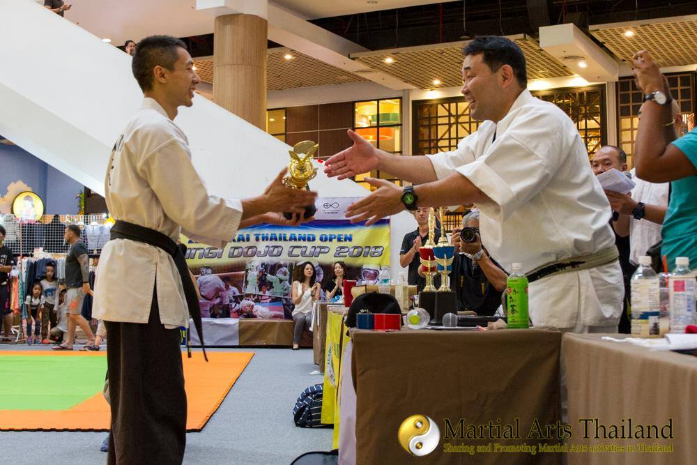 Sakan getting trophy from Kenji Ayama for winning competition  Core Combat Chiang Mai