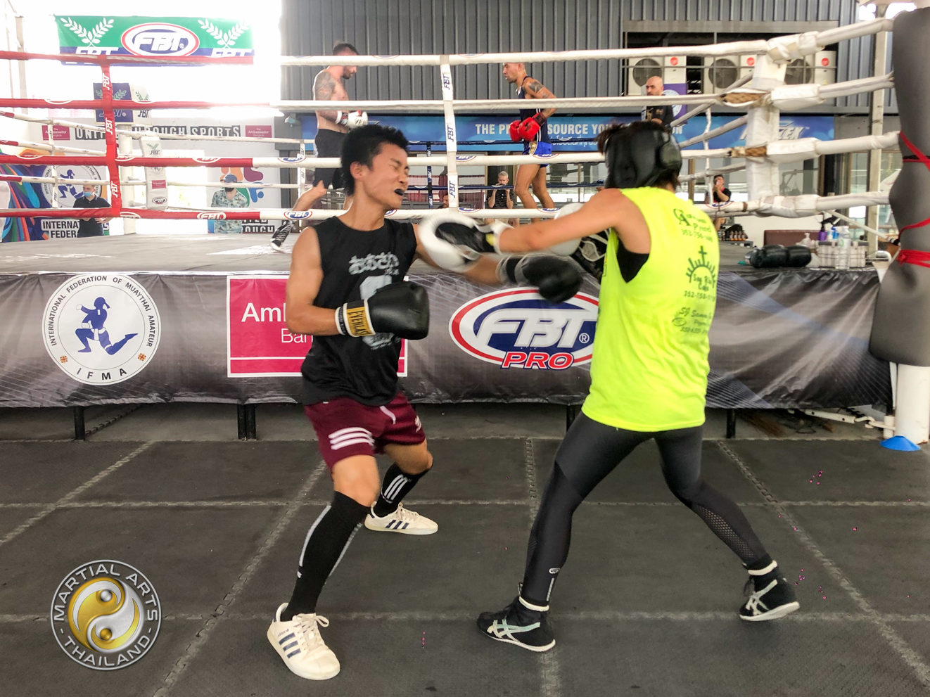 a couple of boxers sparring under the ring at the free open sparring day at The Box Thailand