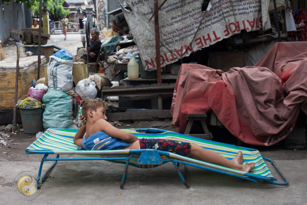 Boy laying on a beach bed in Cebu slums