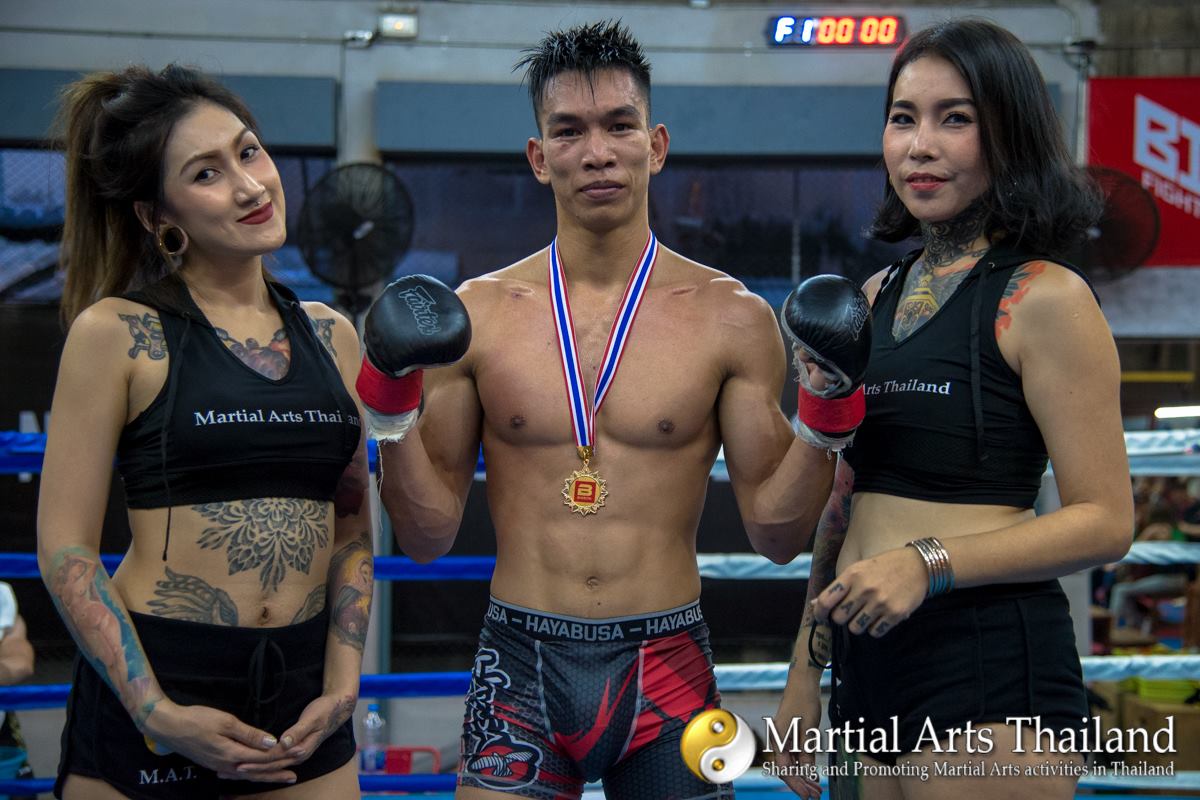 MMA winner with medal and ring girls