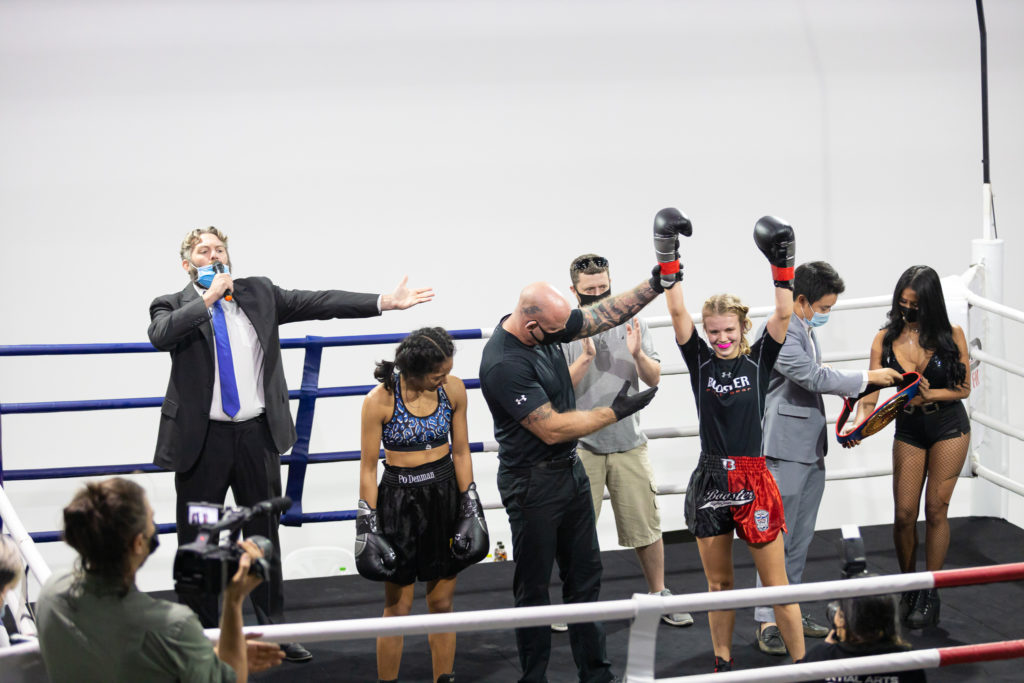 Jon Nutt announcing the winner Marie Ruumet with her hand raised by the referee Nick Chapman, after her boxing fight against Po Denman