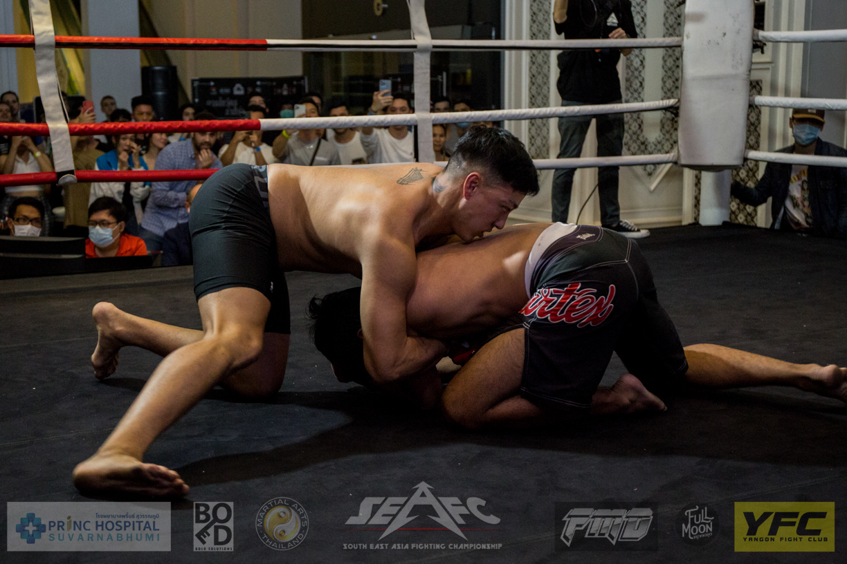 Simon Stracey trying to mount Suwattana Takanratti during their MMA match